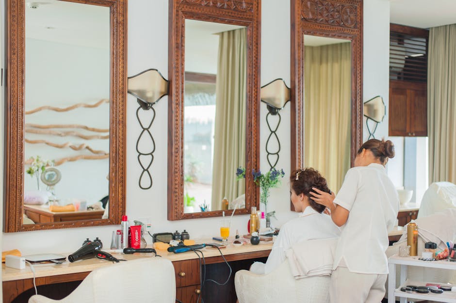 Elegant hair salon interior featuring mirrors, wooden decor, and a hairstylist attending to a client
